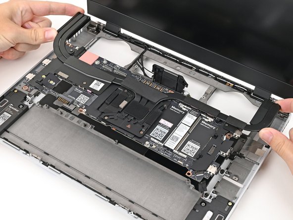 Grab the Mainboard by the curving pipes of its heatsink.