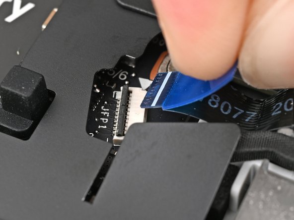Use tweezers, or your fingers, to grip the blue pull tab and slide the fingerprint sensor cable straight out of its socket.