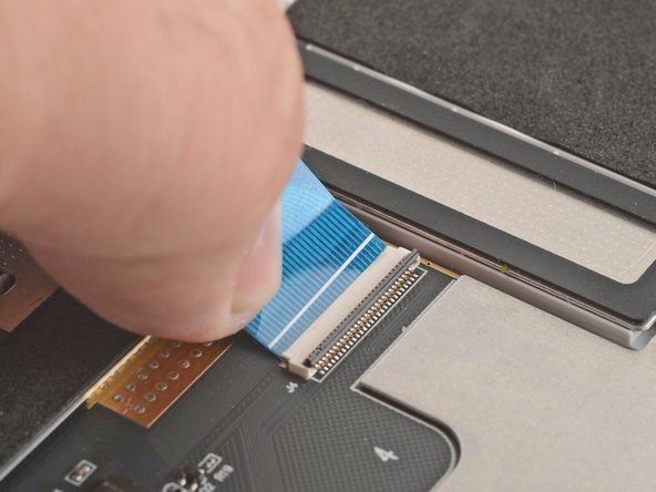 Grab the keyboard cable by the blue tab and slide it out of its connector.