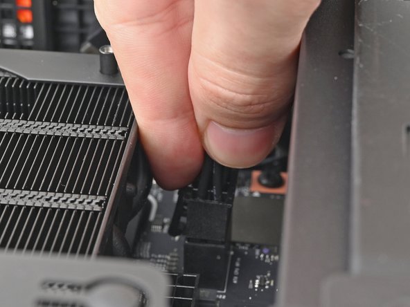 While squeezing the clip on the CPU power cable, pull it straight up and out of its socket to disconnect it.