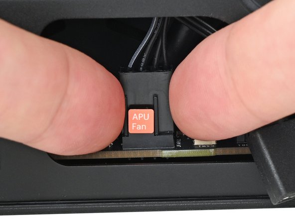 Slide the main fan cable over the four-pronged connector labeled &quot;APU Fan,&quot; making sure the orange label slots between the vertical lines.