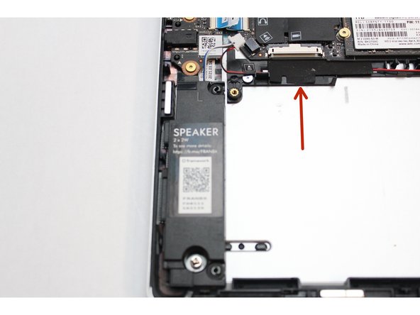 Locate one of two pieces of black tape and carefully peel it back to reveal the black and red speaker wires.