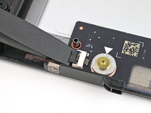 Use the flat end of your Framework Screwdriver, or a clean fingernail, to lift up and release the locking tab on the left fan ZIF connector.