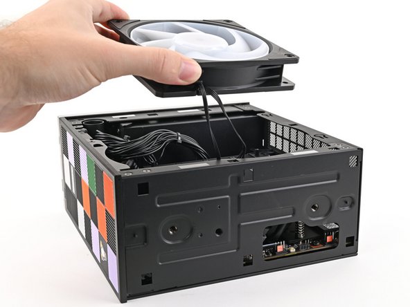 Lift the fan out of the chassis, making sure the cables thread through the side of the heatsink.