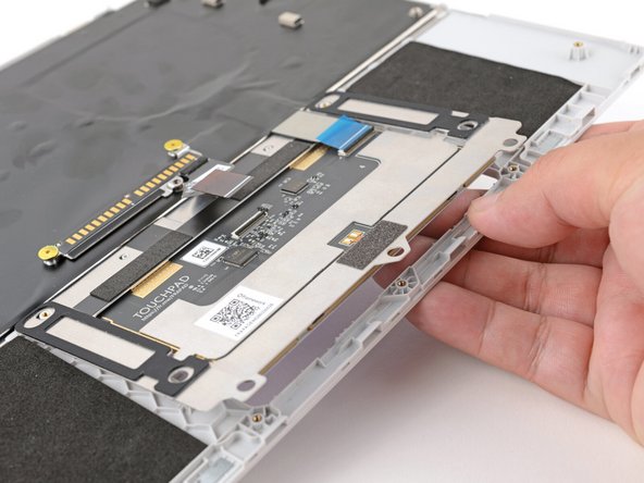 Use your fingers to pop the touchpad out of the Input Cover from the underside.