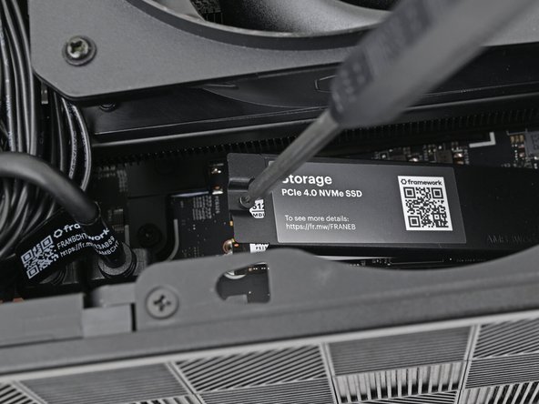 The SSD and its heat spreader will pop up to an angle when its screw is fully loosened.
