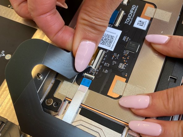 With the black latch lifted , carefully insert the Touchpad cable. The cable should be inserted far enough that the white line almost touches the receptacle as in the first image.