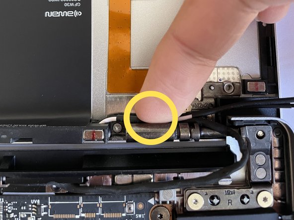 Route the Antenna Cables over the right hinge, through the routing channels near the hinge, through the rubber channels on the Mainboard.