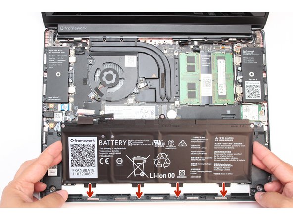 While handling the Framework battery with the plastic frame, slide it into the Bottom Cover. Use the first image as a reference.