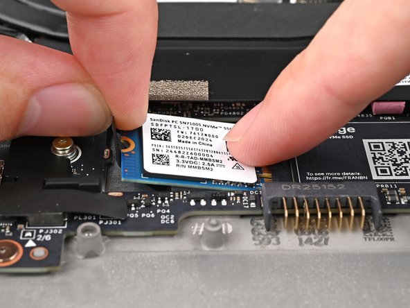 Avoid touching the gold contacts. Only press on the top label or the edges of the SSD.