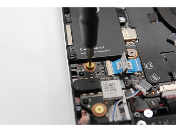 Using the T5 bit in the Framework Screwdriver screw in the two fasteners.
