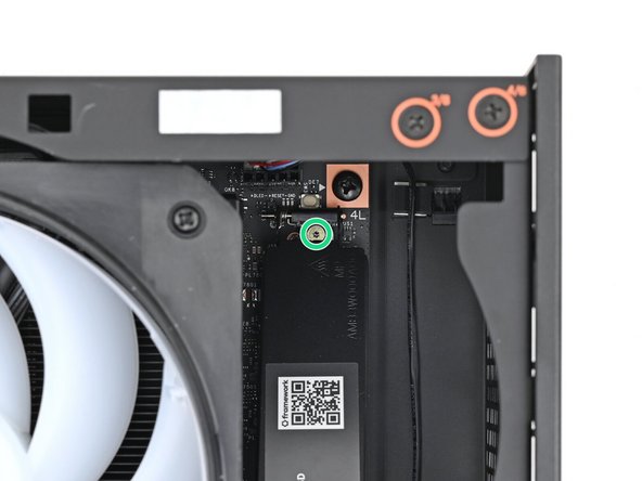 While securing the primary storage heat spreader with one hand, use your Framework Desktop Screwdriver to remove the 4.5 mm‑long T5 Torx screw securing it.