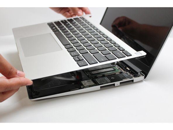 Once the Touchpad cable is secured to the Mainboard, flip the Input Cover over the Bottom Cover so that the keyboard is facing up and attach it to the Bottom Cover by aligning the top and bottom edges of both covers.