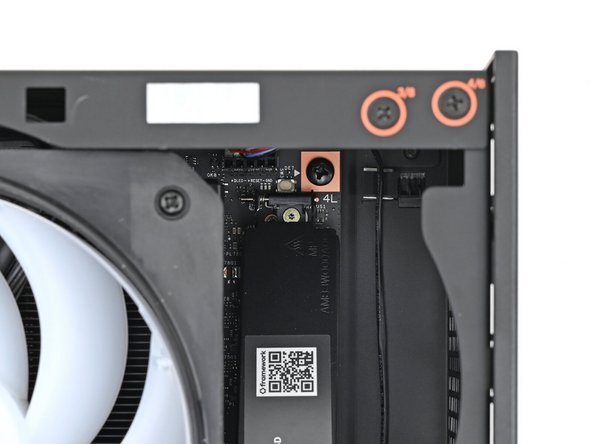 While securing the primary storage heat spreader with one hand, use your Framework Desktop Screwdriver to remove the 4.5 mm‑long T5 Torx screw securing it.