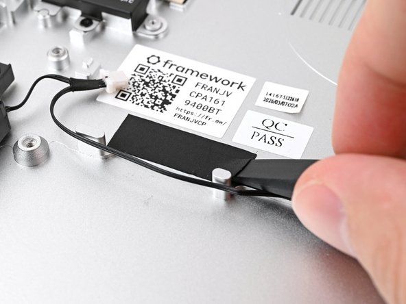 Slide the flat end of your Framework Screwdriver under the black tape and separate one of its long edges from the Chassis.