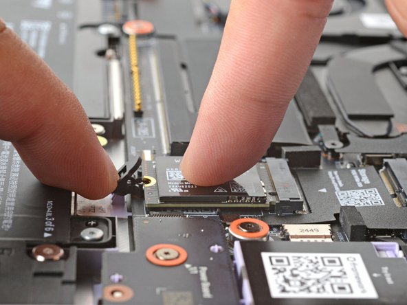 Use another finger to press the SSD down until it lays flat.