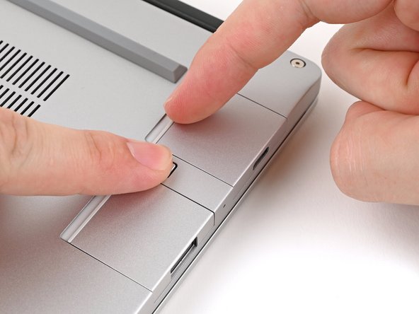 While pressing down the release button, grip the lip of the Expansion Card and pull it out of its slot to release it.