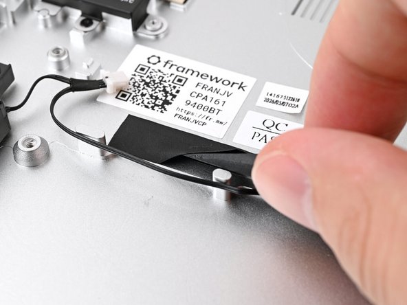 Slide the flat end of your Framework Screwdriver under the black tape and separate one of its long edges from the Chassis.