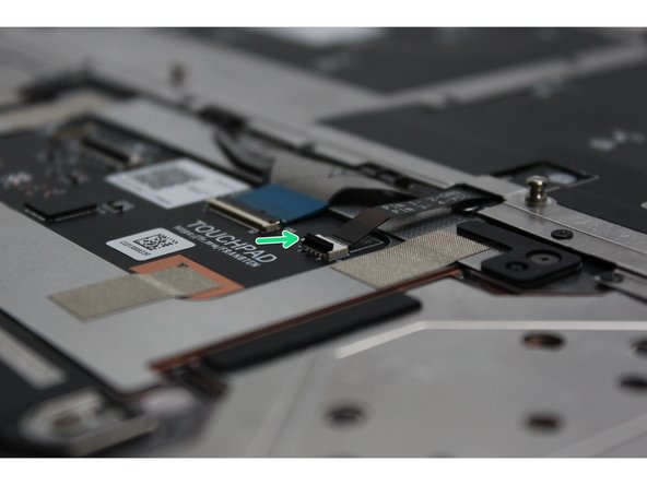 Using the spudger end of the Framework Screwdriver or your fingernail, disconnect the Keyboard Backlight cable from the Touchpad Module by switching the black latch up and sliding the cable straight out.