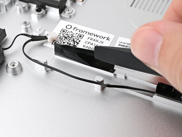 Slide the flat end of your Framework Screwdriver under the black tape and separate one of its long edges from the Chassis.