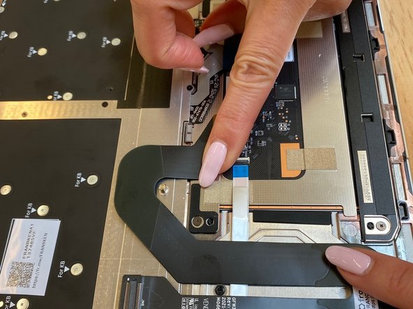 Attach the Touchpad cable to the Input cover by pressing gently on the cable so it sticks.