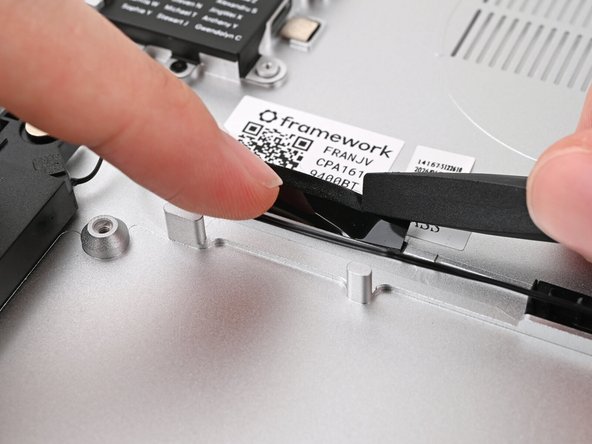 While holding the tape out of the way, lay the Speaker Cable into the channel underneath it.