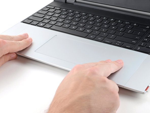 Press the Touchpad Module down and slide it into place so it lines up evenly with the bottom edge of the laptop.