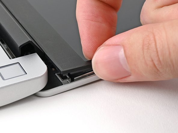 Slide your fingernail under the inside edge of either bottom corner of the bezel.