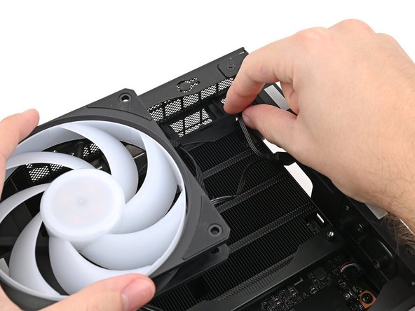 If the cable(s) aren't routed properly, lift the fan up slightly and use your fingers to reposition the cables over the side of the heatsink.