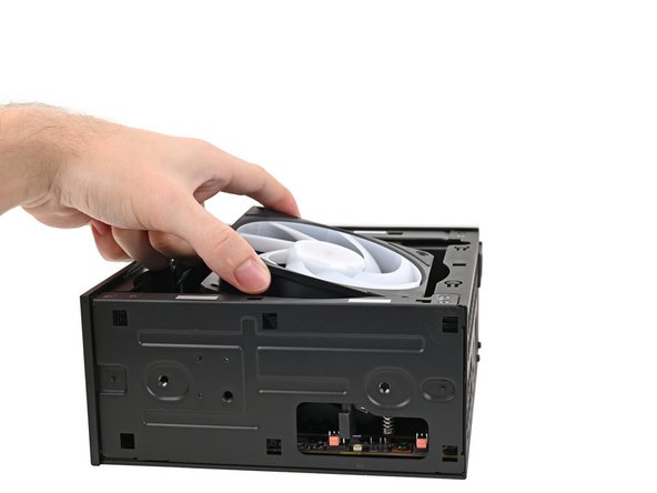 Orient the fan so its label is facing downward and the cable(s) is pointing towards the top of the computer.