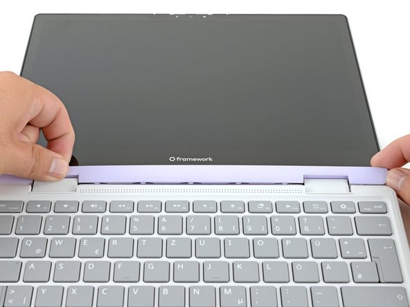 Slide your fingers under the top edge of the Display Cover to release it from the laptop.