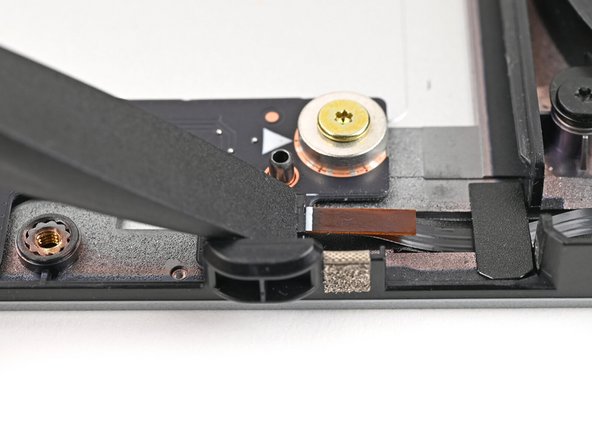 Use the flat end of your Framework Screwdriver, or a clean fingernail, to press down the locking tab on the right fan ZIF connector.