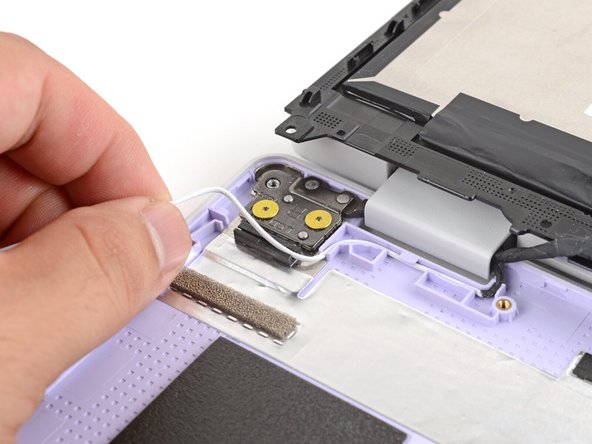 Carefully guide the white antenna cable out of its channel until you reach the hinge.