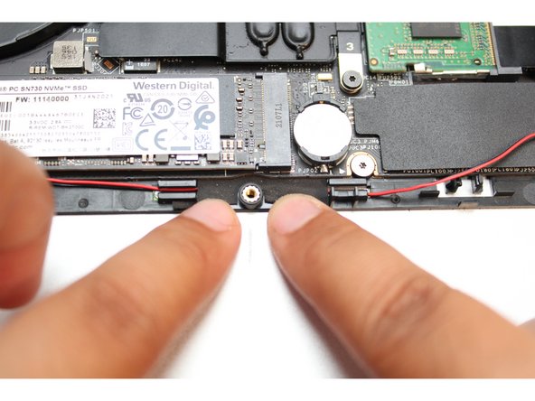 Place the wires into the wire router next to the other piece of black tape.  Peel the tape back and place the wires under it. Cover the wires with same tape.