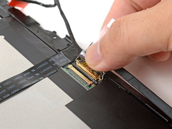 Grab the display cable near the connector and slide it out of the connector.