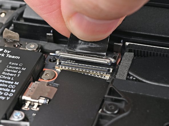 Grip the Display eDP Cable connector by its pull tab and lift up to disconnect it.