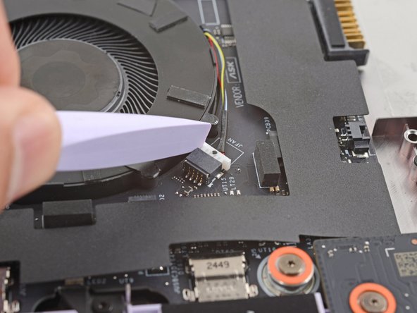 Use the flat end of your Framework Screwdriver to gently push on one of the fan connector's protruding edges, then the other, to loosen the connector out of its socket.