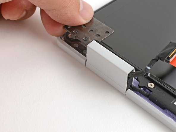 Twist the left hinge plate until it's flipped on top of the display.