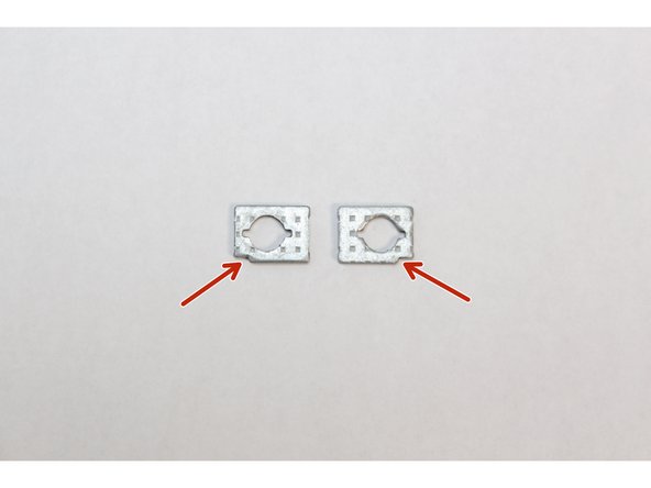 Find the two washers and orient them so that the notch on both washers are located at the bottom corner as indicated with the red arrows in the first image.  These need to be aligned with the notch on the Top Cover.