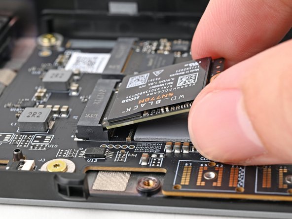 Insert the SSD into the socket at a shallow angle. The gold contacts should mostly be covered by the socket.