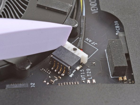 Use the flat end of your Framework Screwdriver to gently push on one of the fan connector's protruding edges, then the other, to loosen the connector out of its socket.