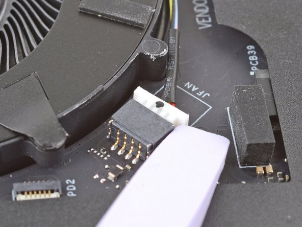 Use the flat end of your Framework Screwdriver to gently push on one of the fan connector's protruding edges, then the other, to loosen the connector out of its socket.