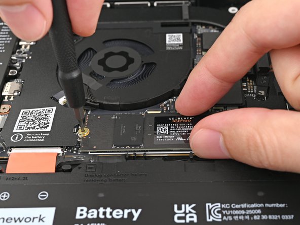 While holding the SSD flat to the Mainboard, use your Framework Screwdriver to install the 3.0 mm‑long T5 Torx screw securing the SSD.