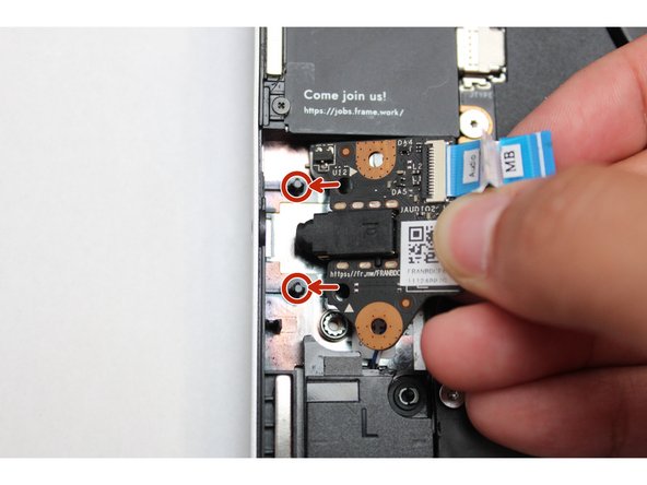 Place the Audio Board down by aligning the holes on the Audio Board with the alignment pins on the Bottom Cover and insert the headphone connector through the hole on the left hand side of the Bottom Cover.