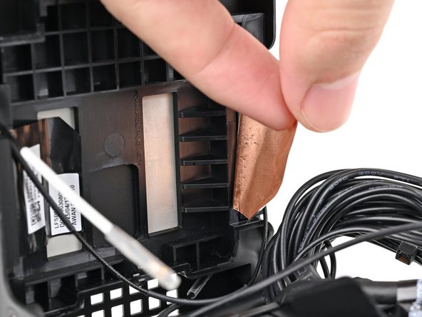 Press the left antenna's copper film onto the chassis and adhere it.