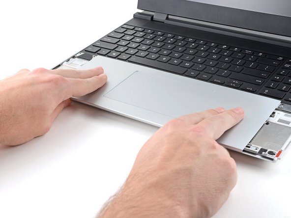 Press the Touchpad Module down and slide it into place so it lines up evenly with the bottom edge of the laptop.