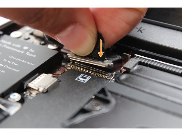 Hold the pull tab on the Display cable and connect it into the Mainboard by aligning the pins from the cable with the socket pins on the Mainboard.