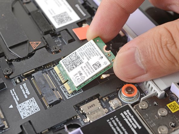 Hold the Wi-Fi card by its edges. Don't touch the gold contacts with your fingers. If you do, wipe the contacts with a clean, lint-free cloth to remove any finger oils.