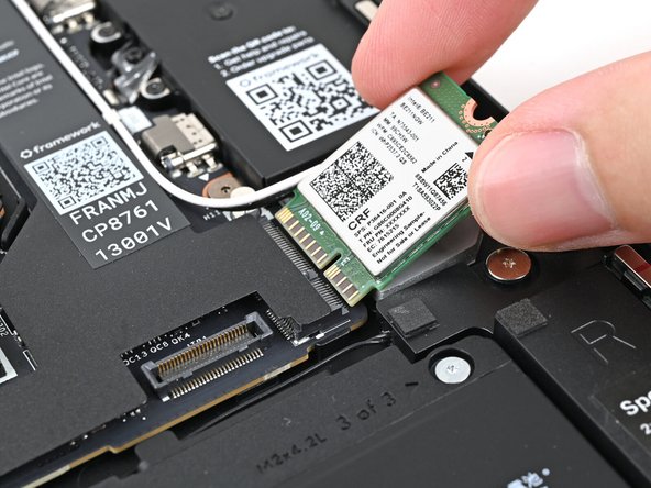 Grip the end of the Wi-Fi module with the screw hole and slide it straight into its socket.