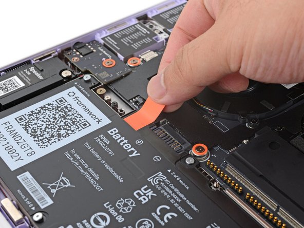 Grab the orange battery tab with your fingers and lift straight up to disconnect the battery.